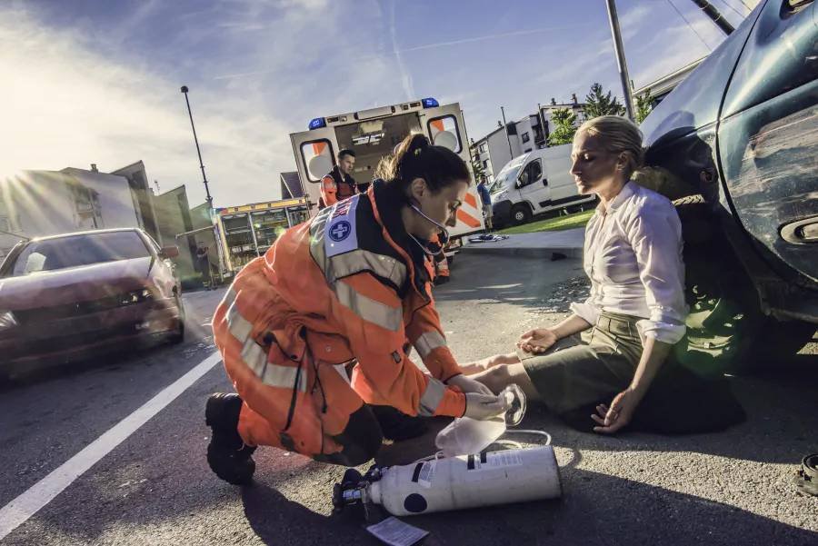 Paramedics attending an injured person at a roadside crash