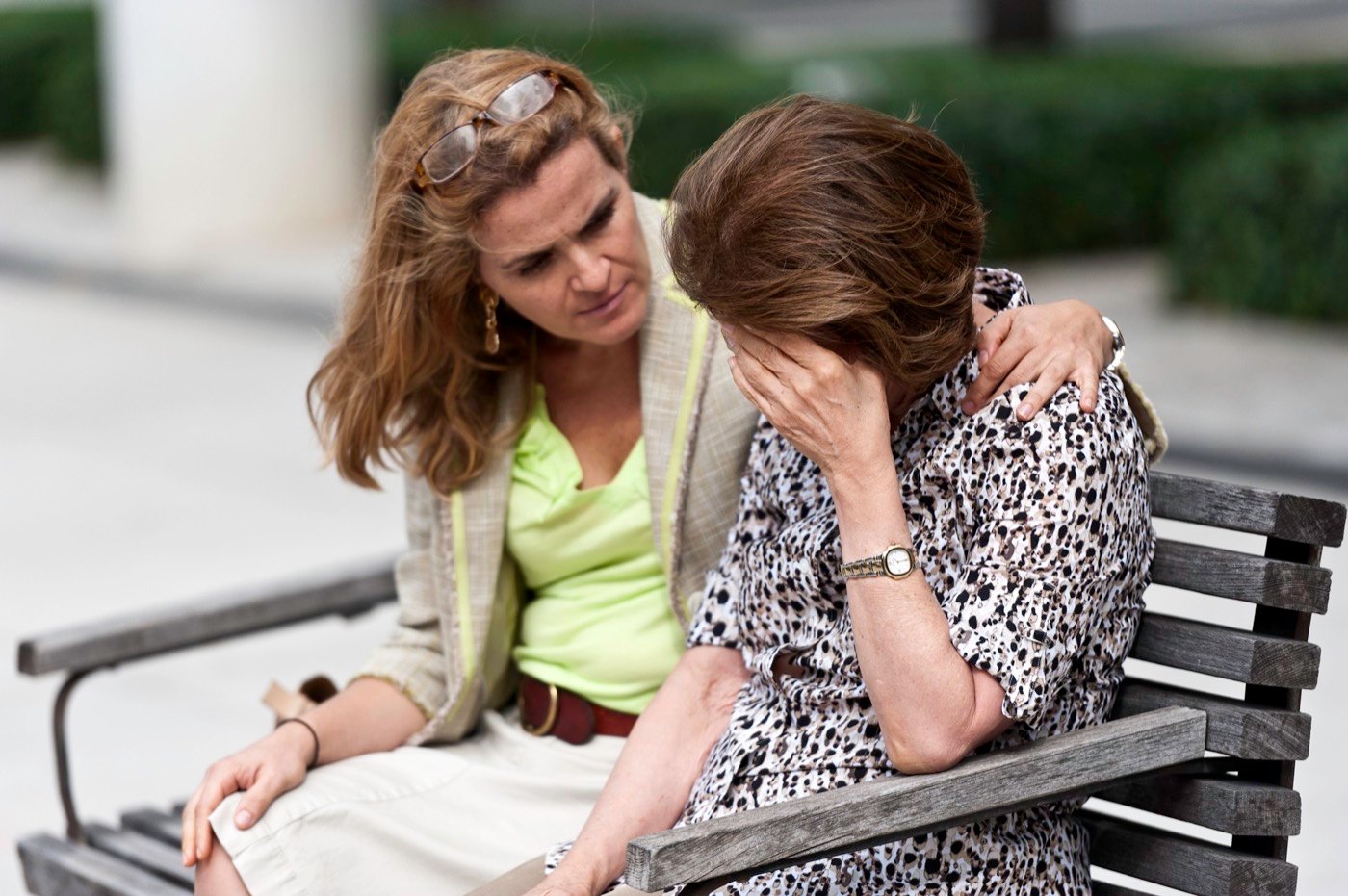 One person comforting another on a bench